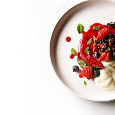 Summer Pudding. Recipe from the Wolseley in London. Pastry Chef Yann Lentilly. Summer berries cooked with sugar, soaking brioche slices and refrigerated in a mold. Served with fresh berries, crème fraiche and mint leaves.